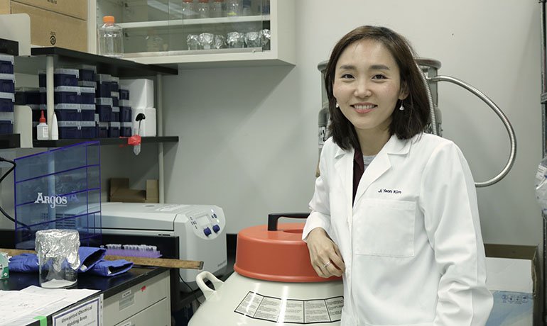 Jiyeon Kim in a lab wearing white coat.