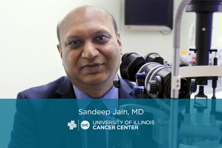photo of Sandeep Jain in a laboratory with his name and the UI Cancer Center logo