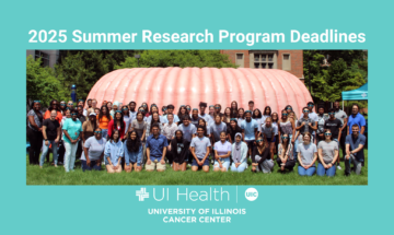 Image of students in summer cancer research programs at the University of Illinois Cancer Center posing in front of CECIL, the Cancer Center's giant inflatable colon.